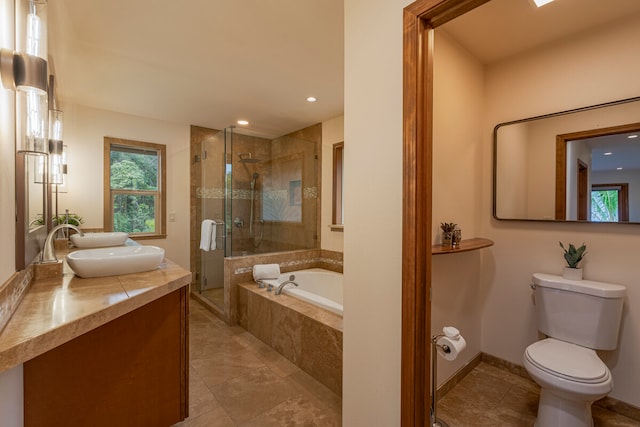 full bathroom featuring tile flooring, vanity, toilet, and shower with separate bathtub