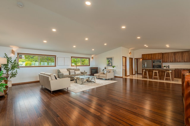 living room with dark hardwood / wood-style flooring and vaulted ceiling