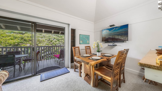 carpeted dining space featuring high vaulted ceiling and plenty of natural light