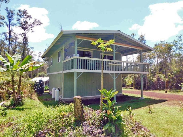 rear view of property with a deck and a lawn