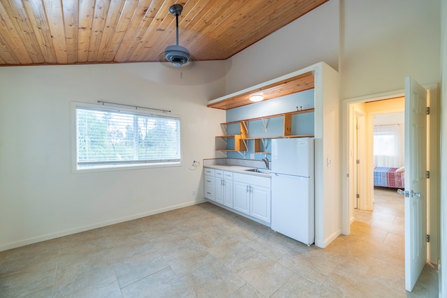 kitchen with ceiling fan, white fridge, wood ceiling, light tile floors, and white cabinets