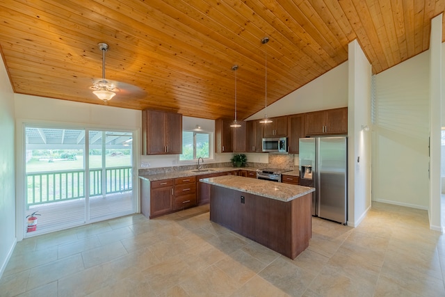 kitchen featuring hanging light fixtures, appliances with stainless steel finishes, a center island, and light tile floors