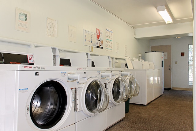 clothes washing area featuring water heater, washing machine and clothes dryer, and dark colored carpet