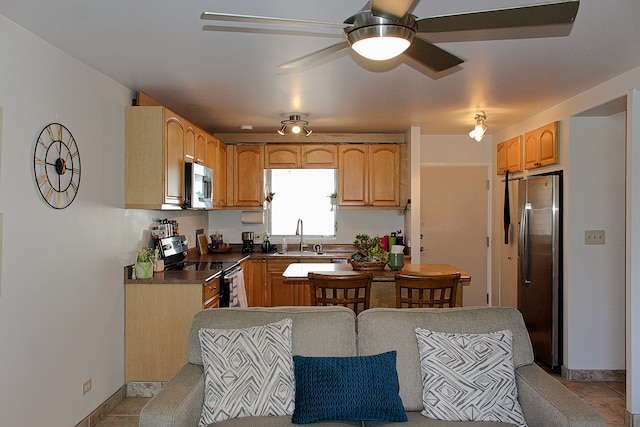 kitchen featuring ceiling fan, sink, light tile patterned floors, and stainless steel appliances