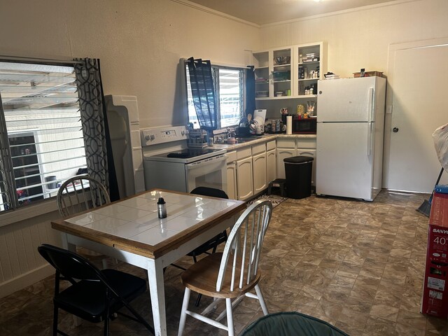 kitchen with white appliances, sink, crown molding, tile countertops, and tile patterned floors