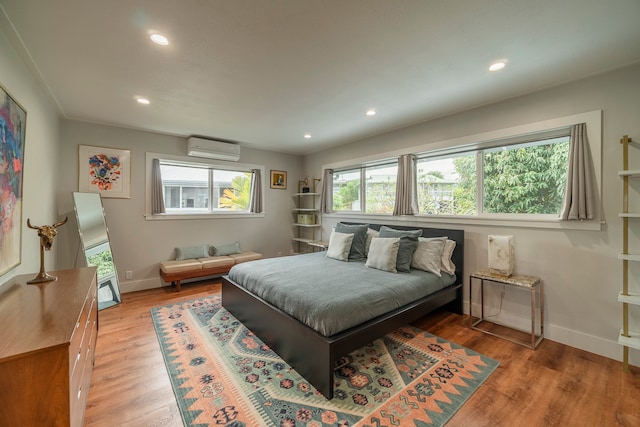 bedroom featuring wood-type flooring and an AC wall unit