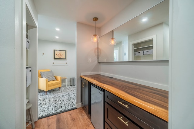 interior space featuring wood counters, light tile floors, and pendant lighting