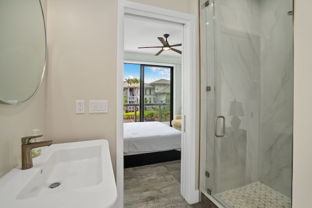 bathroom with ceiling fan, a shower with door, and sink