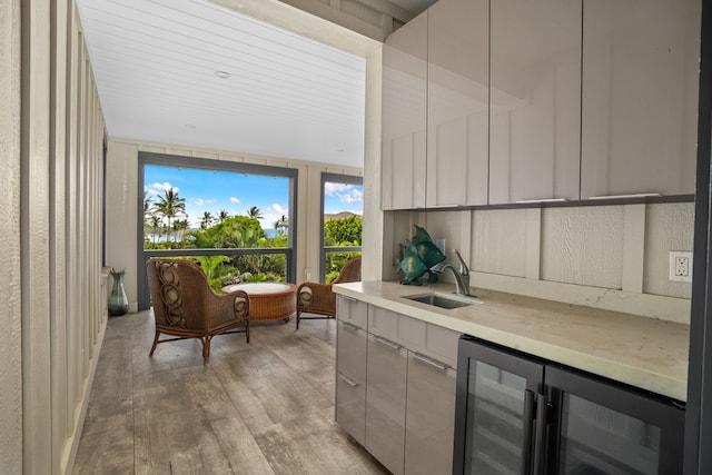 kitchen featuring sink, beverage cooler, and light hardwood / wood-style floors