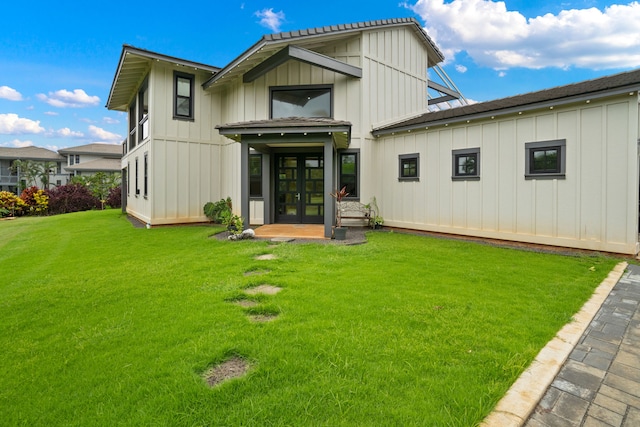 back of house featuring french doors and a lawn