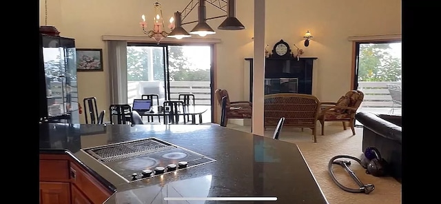 kitchen with a notable chandelier, stovetop, and decorative light fixtures