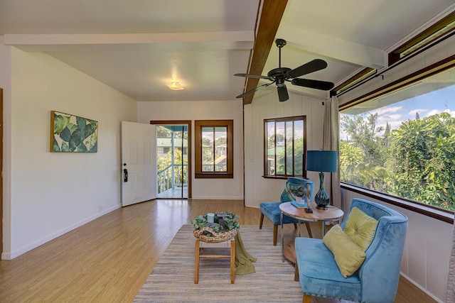 living area featuring ceiling fan, lofted ceiling with beams, and light hardwood / wood-style flooring