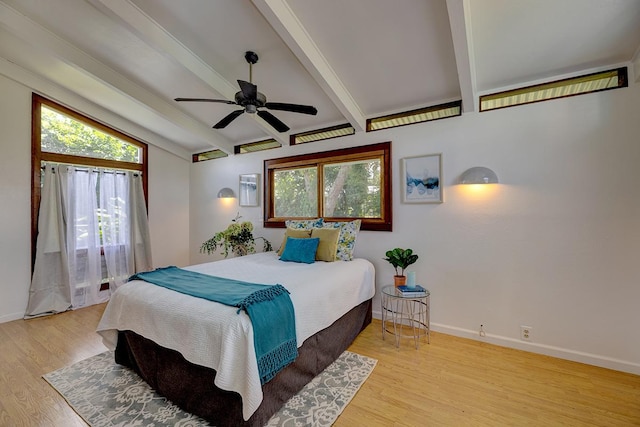 bedroom with beamed ceiling, ceiling fan, and light wood-type flooring