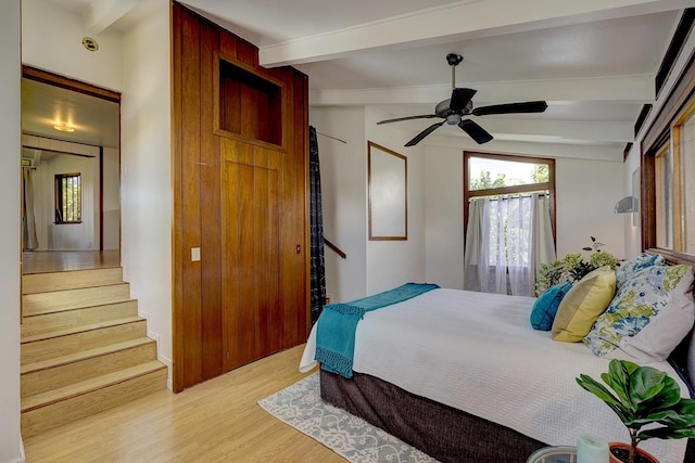 bedroom with vaulted ceiling with beams, ceiling fan, and light hardwood / wood-style floors