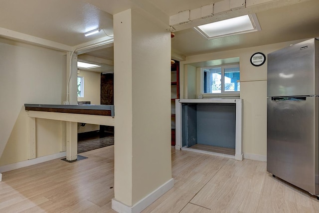 kitchen with stainless steel refrigerator and light hardwood / wood-style floors