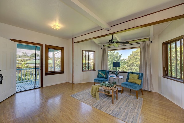 sitting room with ceiling fan, lofted ceiling with beams, and light hardwood / wood-style flooring