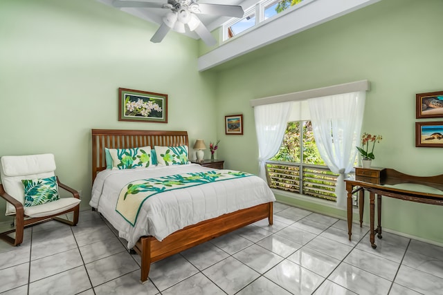 bedroom featuring tile floors, ceiling fan, multiple windows, and a towering ceiling