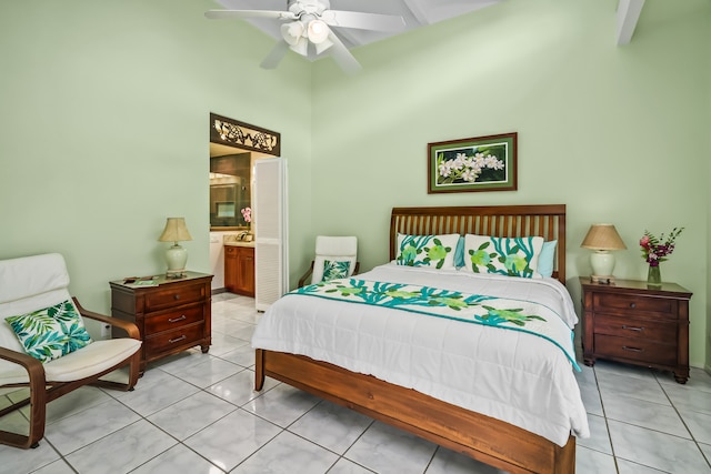 bedroom with beam ceiling, tile floors, ensuite bathroom, and ceiling fan