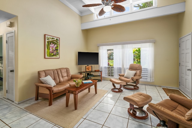 tiled living room featuring plenty of natural light, ceiling fan, and a towering ceiling