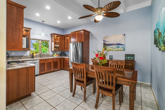 kitchen featuring hanging light fixtures, stainless steel appliances, light stone counters, light tile flooring, and ceiling fan