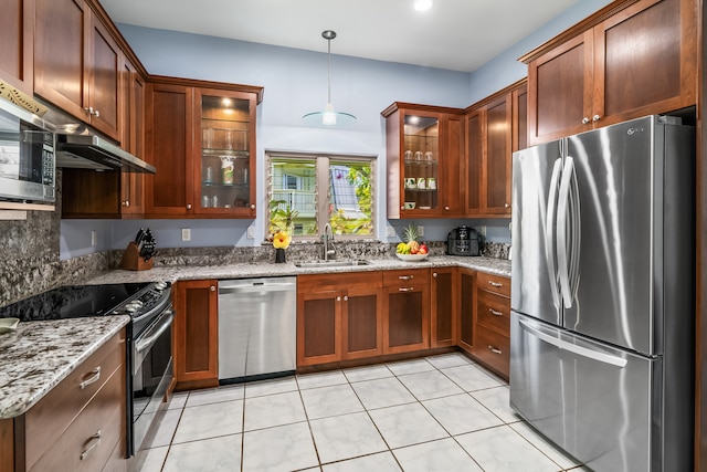 kitchen featuring stainless steel appliances, hanging light fixtures, light stone countertops, and light tile floors