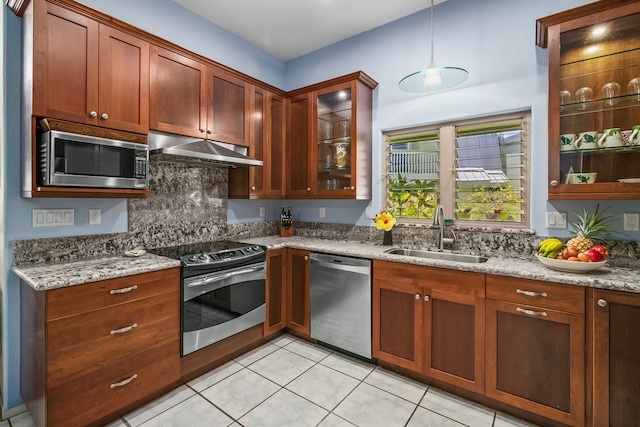 kitchen with stainless steel appliances, hanging light fixtures, tasteful backsplash, sink, and light tile floors