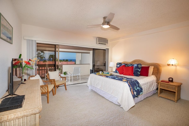 carpeted bedroom with access to exterior, a textured ceiling, an AC wall unit, and ceiling fan