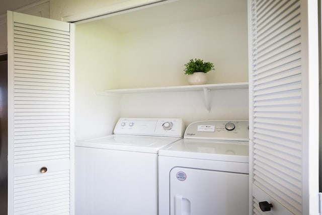 clothes washing area with washer and clothes dryer