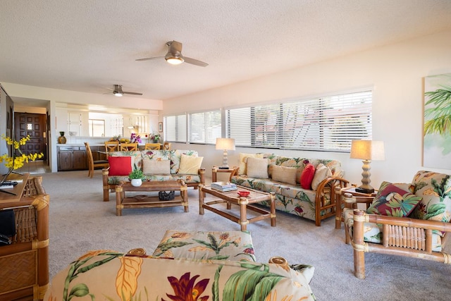 carpeted living room featuring ceiling fan and a textured ceiling