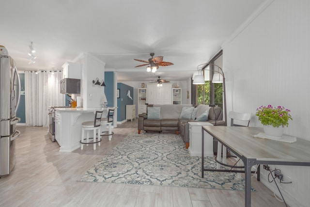 living room featuring crown molding, ceiling fan, light hardwood / wood-style floors, and track lighting