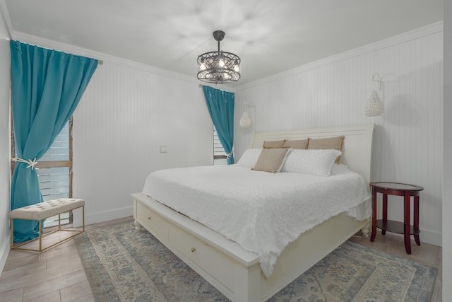 bedroom with wood-type flooring, a chandelier, and ornamental molding