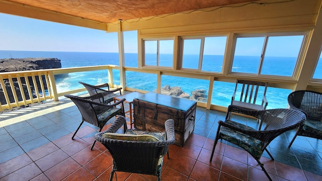 sunroom featuring a water view