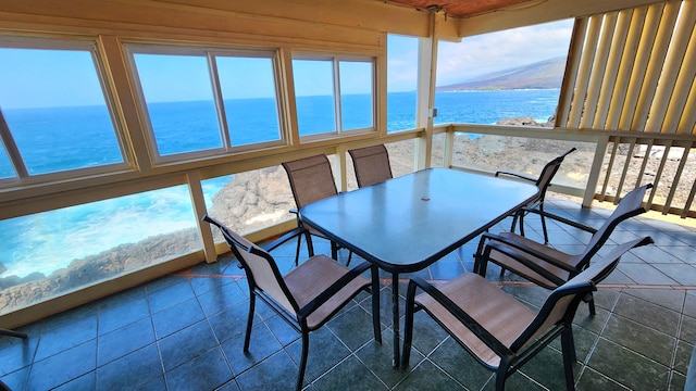 sunroom / solarium featuring a water view