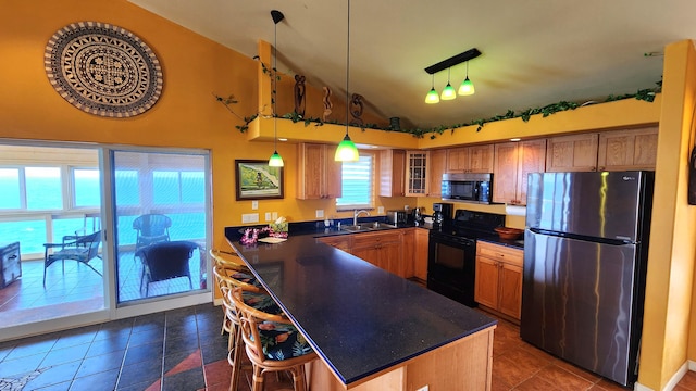 kitchen featuring black electric range, decorative light fixtures, dark countertops, glass insert cabinets, and freestanding refrigerator