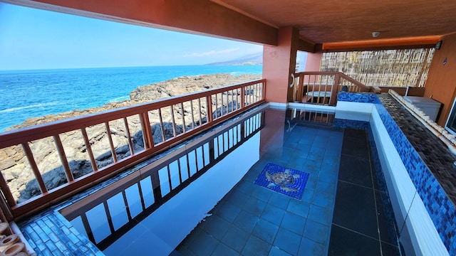 balcony featuring a water view and a beach view