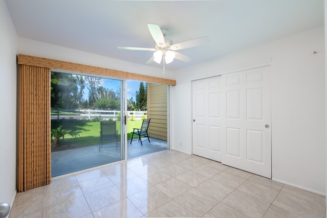 interior space with ceiling fan, light tile patterned flooring, access to exterior, and a closet