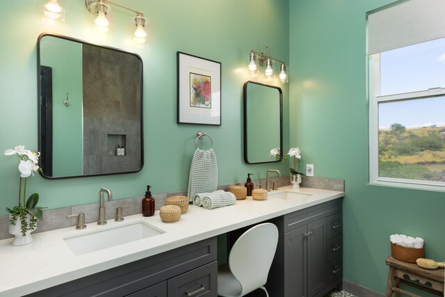 bathroom with a tile shower and dual bowl vanity