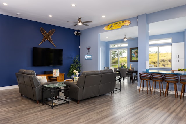 living room featuring wood-type flooring and ceiling fan