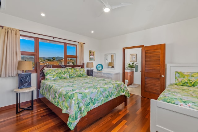 bedroom featuring ceiling fan, connected bathroom, and hardwood / wood-style flooring