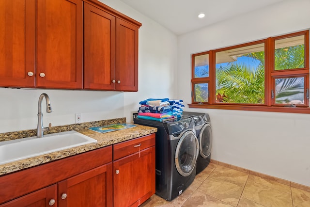 washroom featuring washer and dryer, cabinets, sink, and light tile flooring