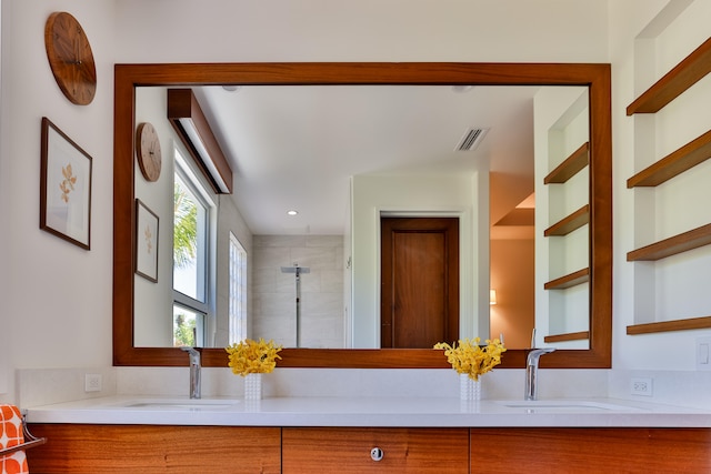 bathroom featuring a tile shower and vanity