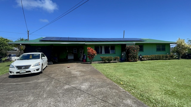 single story home featuring a carport, solar panels, and a front lawn