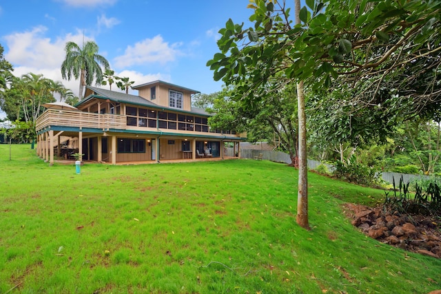 back of house with a lawn and a sunroom