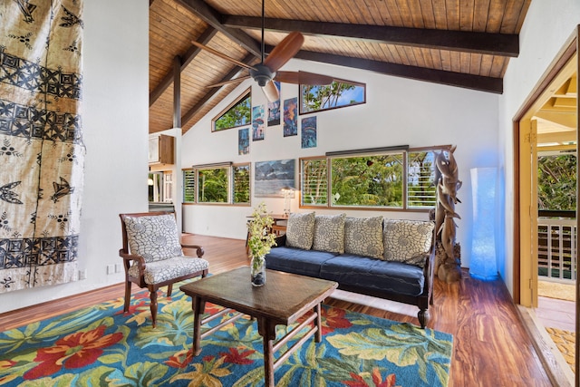 living room with a healthy amount of sunlight, wood-type flooring, and high vaulted ceiling