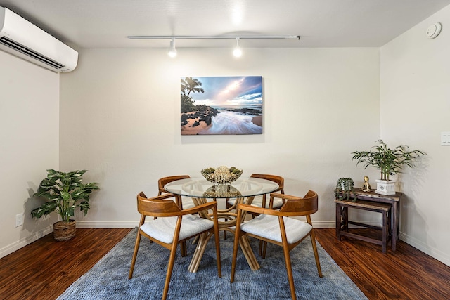 dining area featuring dark hardwood / wood-style flooring, track lighting, and a wall mounted air conditioner