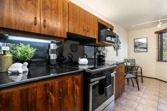 kitchen with backsplash, electric range, light tile patterned floors, and track lighting