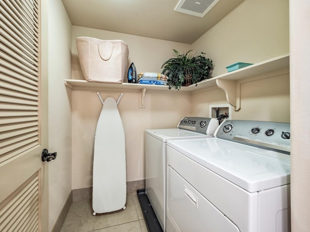 washroom with washer and clothes dryer and light tile patterned flooring