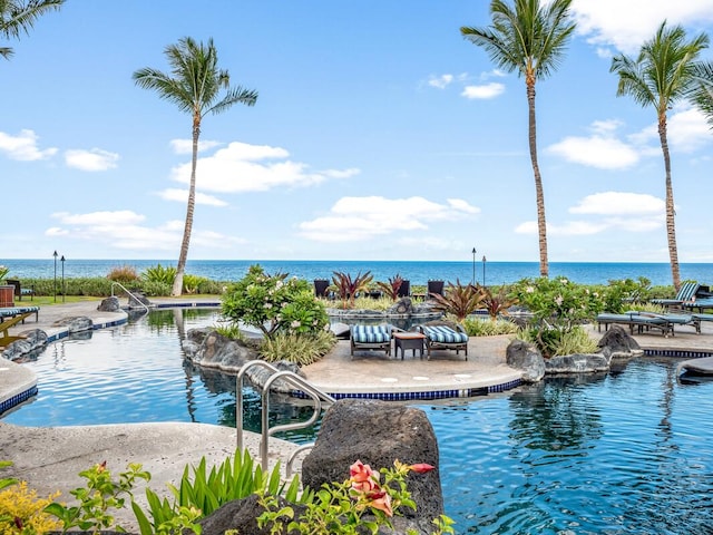 view of swimming pool with a water view and a patio area