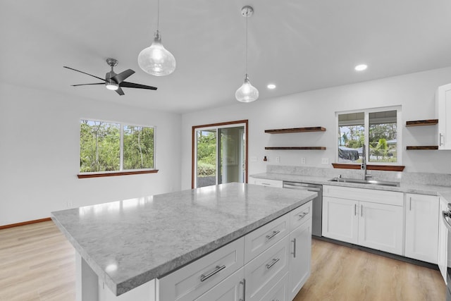 kitchen featuring a center island, sink, decorative light fixtures, light hardwood / wood-style floors, and white cabinetry