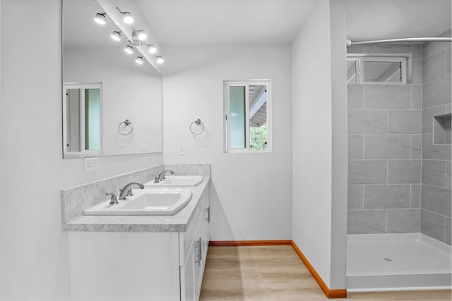 bathroom with vanity, wood-type flooring, and tiled shower